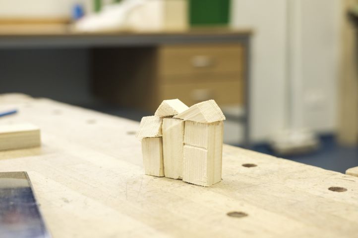 Holzklötze auf einer Werkbank bilden ein Haus