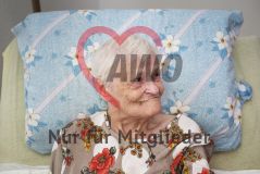 Eine alte Frau Seniorin liegt im Bett und lächelt