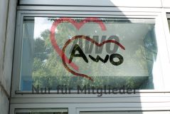Das AWO Logo einem Fesnter über einer Tür einer Einrichtung
